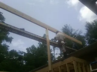 Carpenter setting a ridge beam over a new addition frame — Ice Dam Removal by Roofing Brothers in Annandale On Hudson