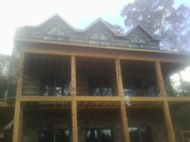 Dormers and porch framing on a large log home under construction — Roof Coating work by our crew in Annandale On Hudson